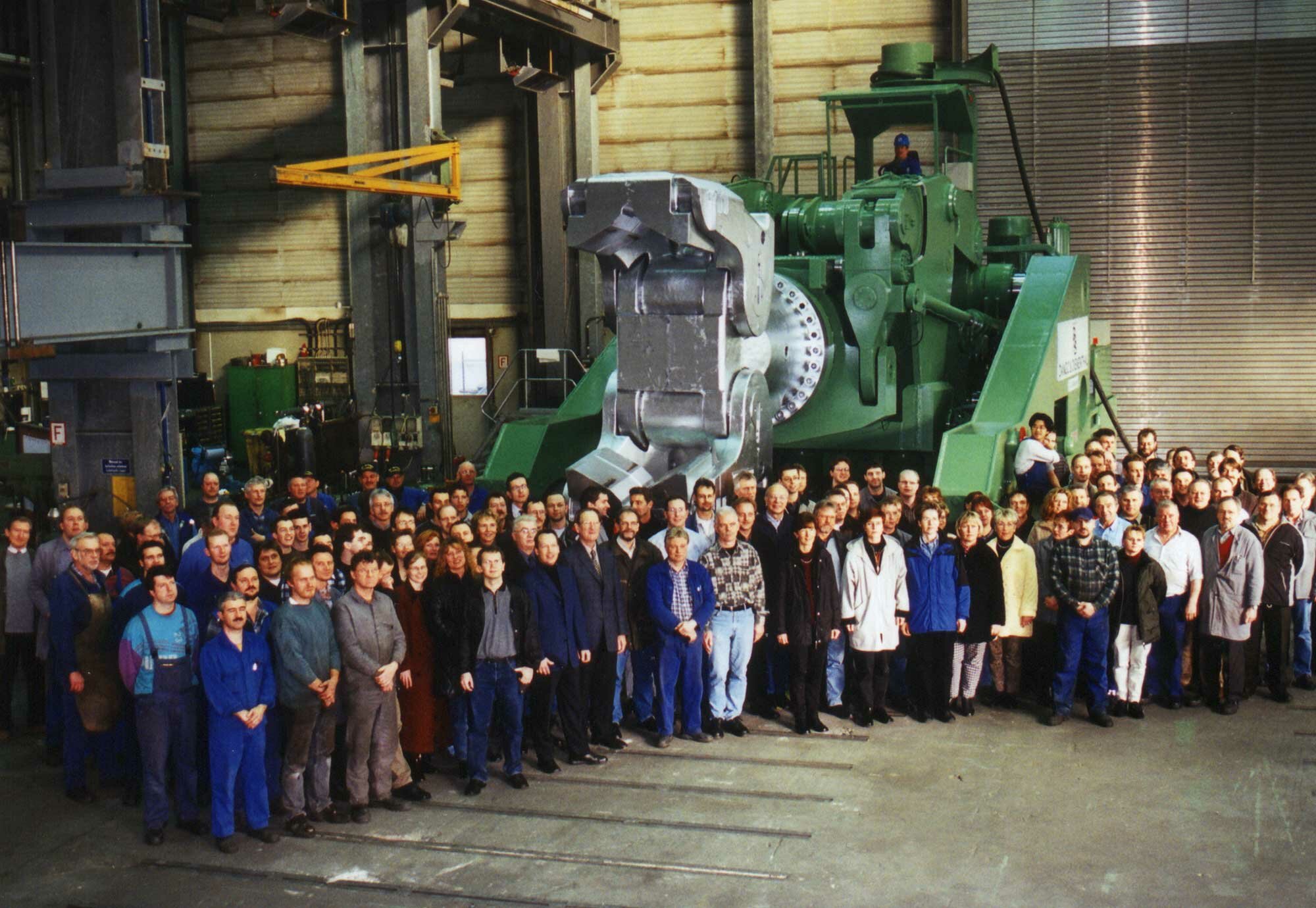 Mobile forging manipulator in the background and team in the foreground
